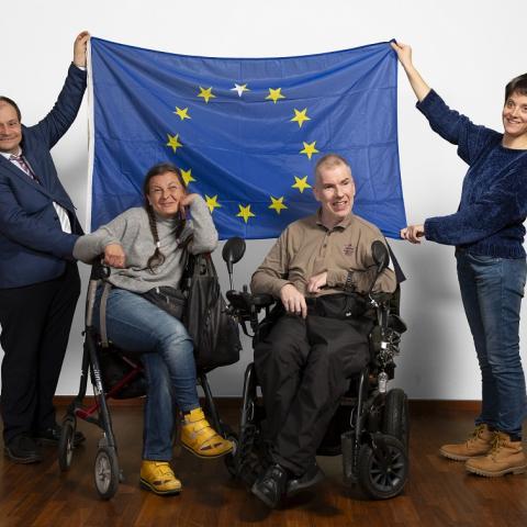 Vier People-First-Vertreter/innen mit der Europa-Flagge