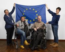 Vier People-First-Vertreter/innen mit der Europa-Flagge