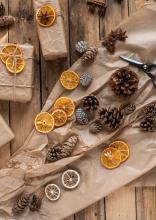 Carta da regalo marrone, bucce d'arancia e pigne