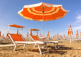 Zwei Liegestühle und ein Sonnenschirm am Strand