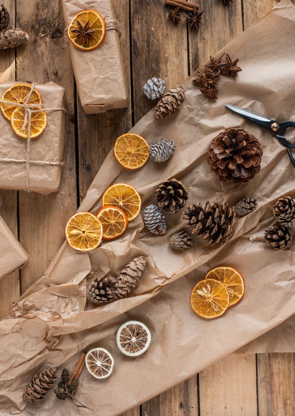 Carta da regalo marrone, bucce d'arancia e pigne
